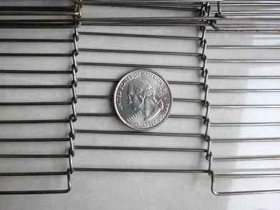 A part of ladder shaped conveyor belt with a metal coin on its surface.