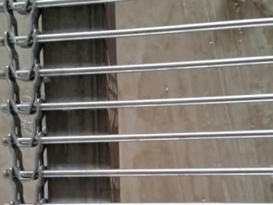 A rod conveyor belt is placed on the shelf with U-shaped link edge.
