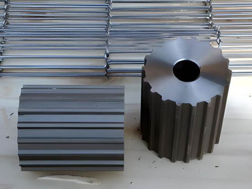 Two metal idler wheels are beside of flexible flax conveyor belt.