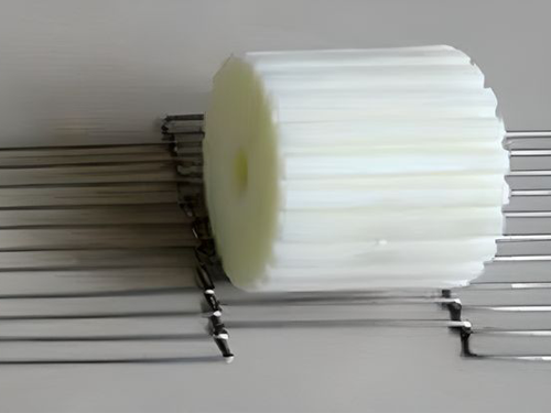 A plastic idler wheel on the flexible flax conveyor belt.