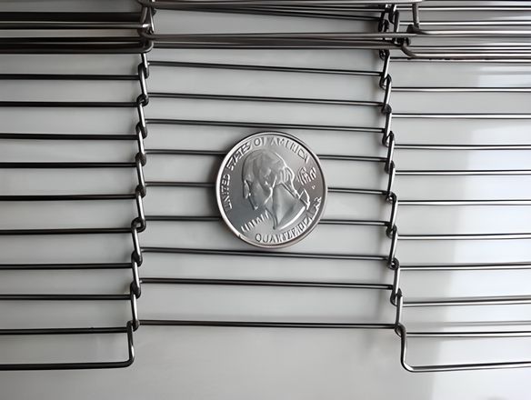 A part of ladder shaped conveyor belt with a metal coin on its surface.